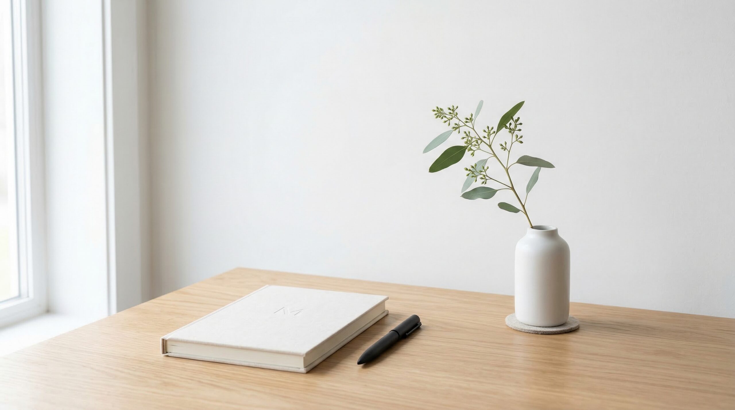Minimalist workspace with notebook and single flower